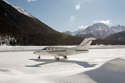 Scenic view of airplane on snow against sky