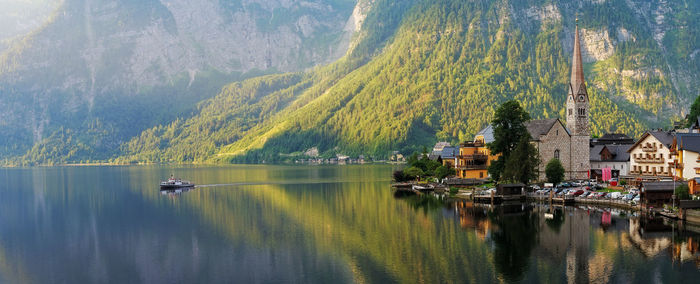 Panoramic view of lake by buildings and mountains