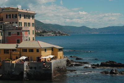 Buildings by sea against sky in city