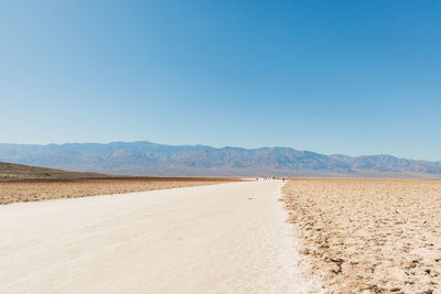 Scenic view of desert against clear blue sky