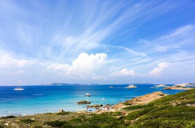 Scenic view of sea against cloudy sky on sunny day