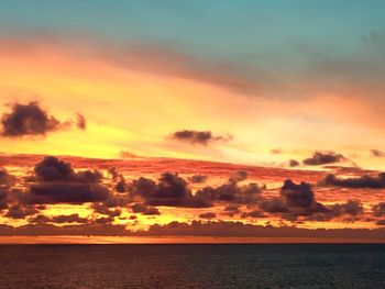 Scenic view of sea against dramatic sky during sunset