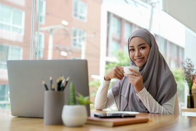 Young woman using mobile phone in cafe