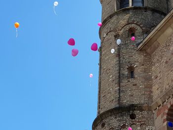 Low angle view of balloons against building