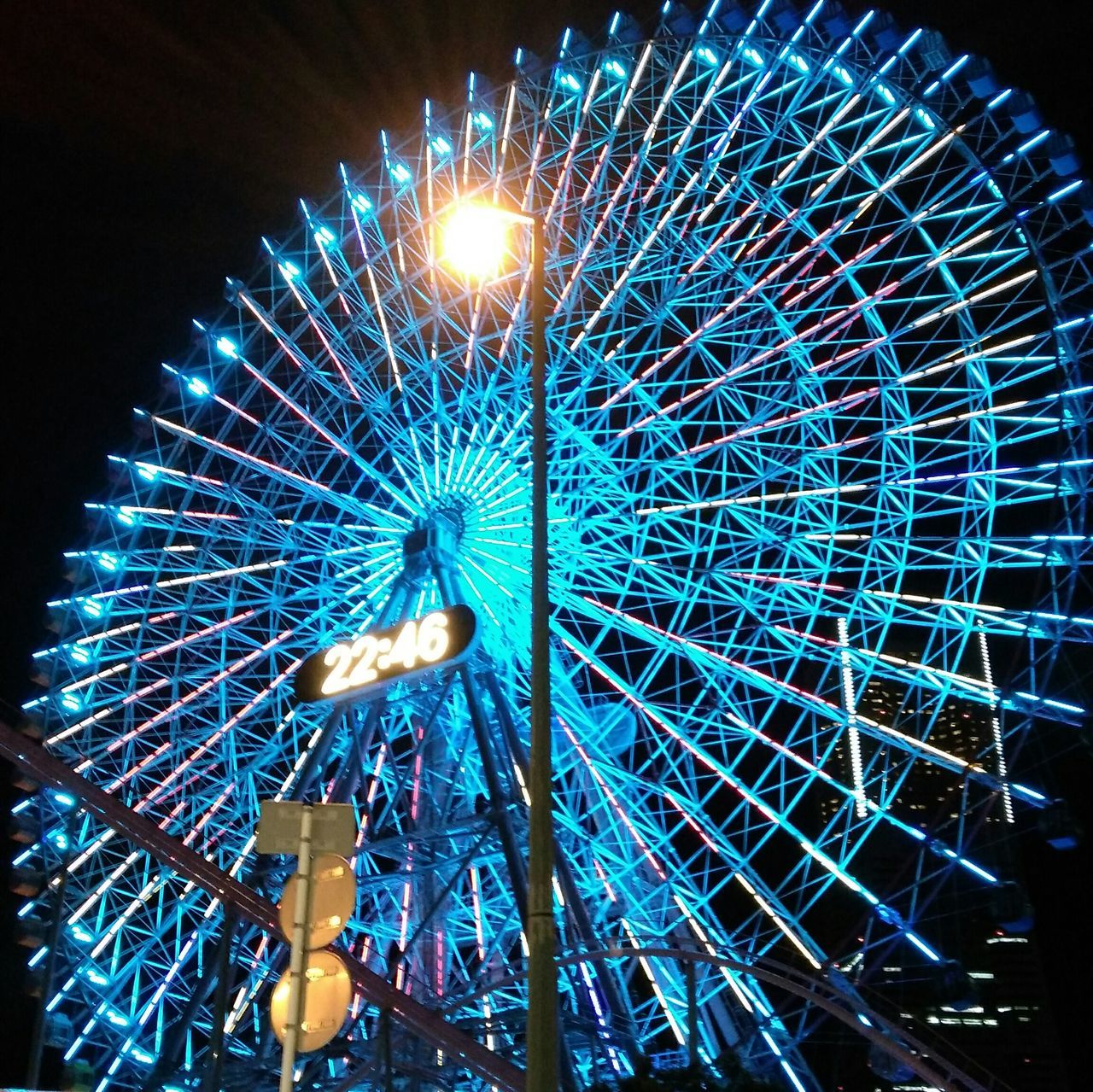 arts culture and entertainment, amusement park, ferris wheel, low angle view, amusement park ride, illuminated, sky, fun, blue, enjoyment, tourism, multi colored