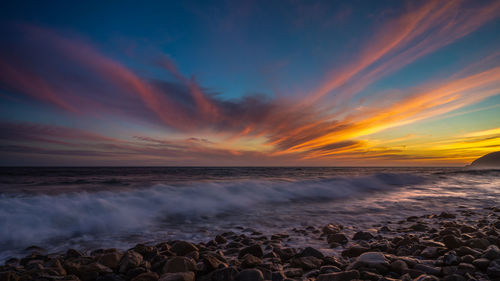 Scenic view of sea against sunset sky