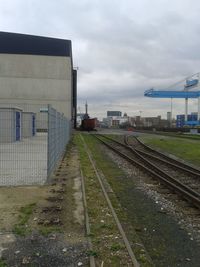 Railroad track against cloudy sky