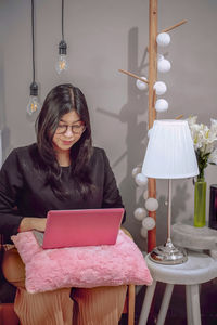 Woman sitting on table at home