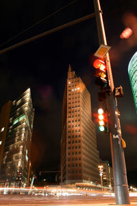 Low angle view of illuminated cityscape against sky at night