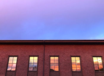 Low angle view of building against clear sky at sunset