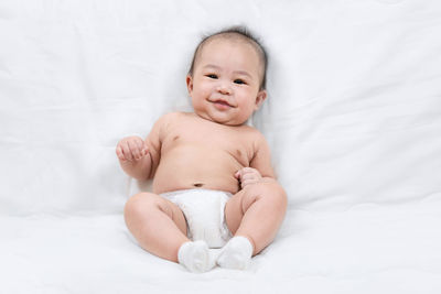 Cute baby girl lying on bed