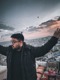 Young man standing at observation point against sky