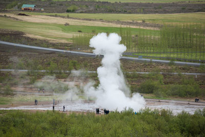 Tourists visiting and waiting for the eruption of strokkur geyser in iceland