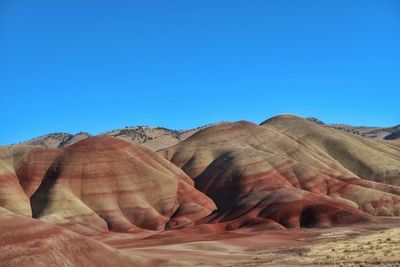 Rock formations in desert against clear blue sky