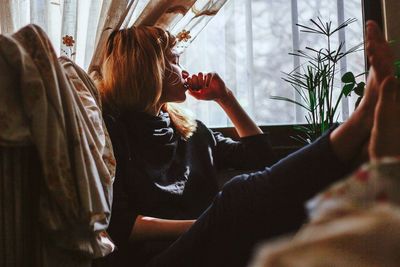 Rear view of woman sitting at home