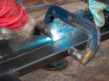 Cropped hands of welder welding in factory