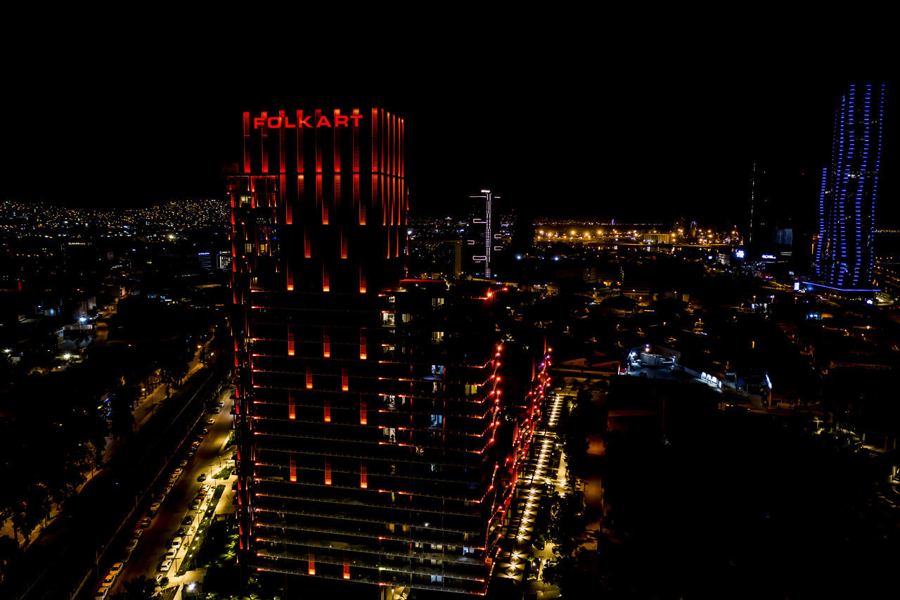 HIGH ANGLE VIEW OF ILLUMINATED CITY BUILDINGS AT NIGHT