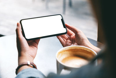 Cropped image of hand holding coffee cup