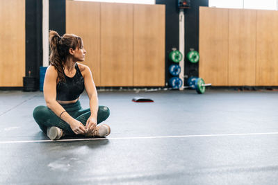 Full length of young woman sitting on floor