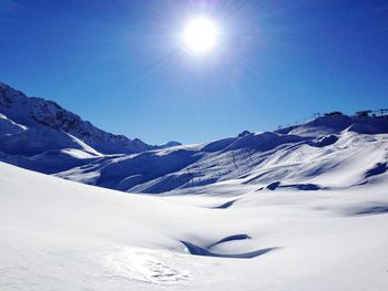 Scenic view of snowcapped mountains against clear blue sky