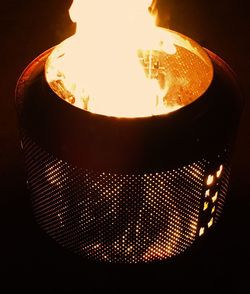 Close-up of illuminated light bulb against black background