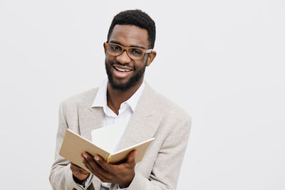 Portrait of young man standing against white background