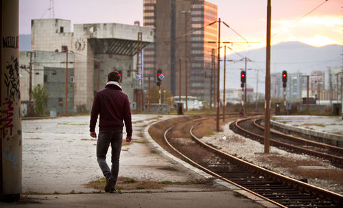 Rear view of man walking on railroad station platform