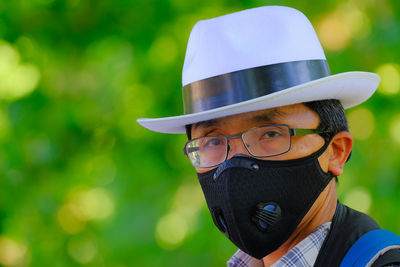Close-up portrait of man wearing mask and eyeglasses outdoors