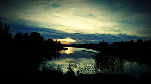 Scenic view of river against sky at sunset