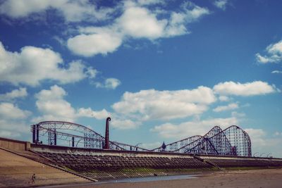 Rollercoaster against cloudy sky