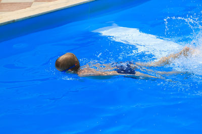 High angle view of boy swimming in pool