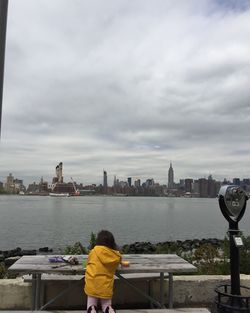 Rear view of woman standing on riverbank