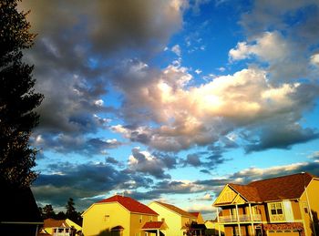 Low angle view of houses against cloudy sky