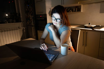 Woman working late on laptop at home