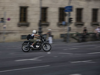 Blurred motion of man riding motorcycle on road