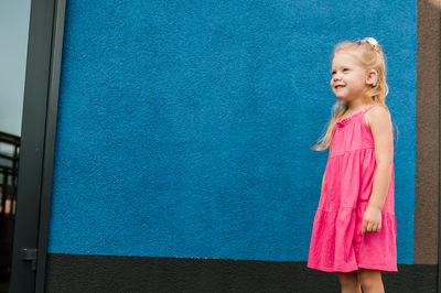 Young woman standing against wall