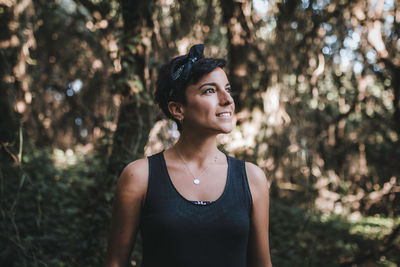 Portrait of young woman looking away in forest