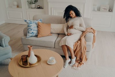 Woman sitting on sofa at home