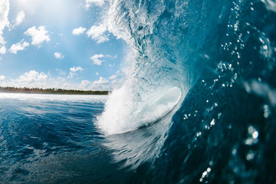 Close-up of waves splashing in sea against sky