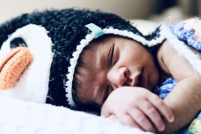 Close-up of baby boy sleeping on bed at home