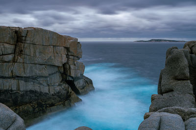 Rock formations by sea against sky