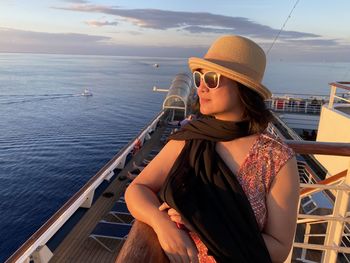 Woman wearing sunglasses at sea against sky