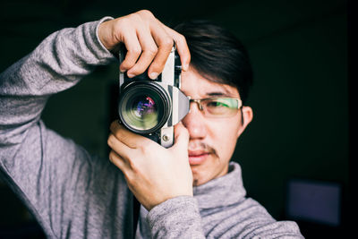 Portrait of young man holding camera