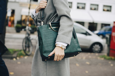 Midsection of woman standing on street