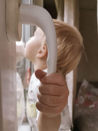 Cute girl standing by window at home