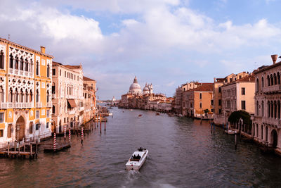 Boats in canal amidst buildings in city