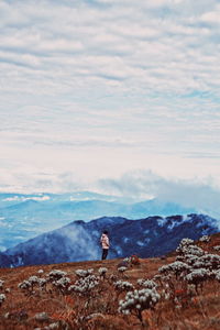 Man standing on mountain against sky