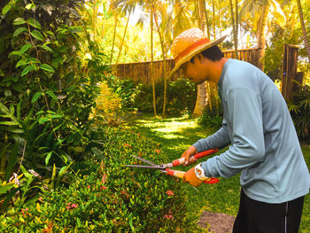 Man cutting plants in garden