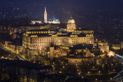 Illuminated royal palace of buda in city at night