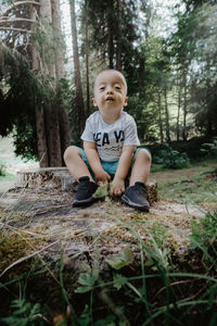 Portrait of boy sitting in forest